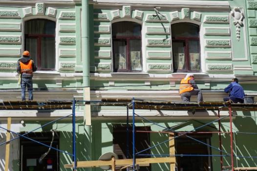 Construction workers repairing siding on building