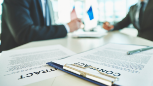 Sometimes You Just Need to Call it a Day: Court Finds That Contractor Not Entitled to Recover Costs After Public Works Contract is Invalidated Two businessmen across from table with contracts