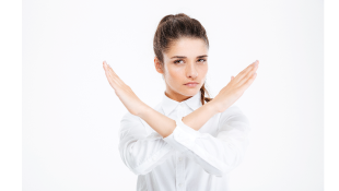 Businesswoman holding up arms in an X