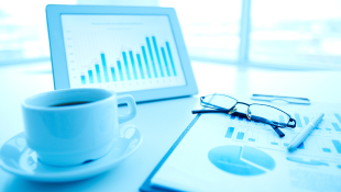 Real Estate & Construction News Round-Up (02/15/23) – Proptech Solutions, Supply Chain Pivots, and the Inflation Reduction Act Tablet with coffee cup and chart