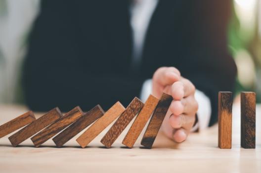 Man stopping dominoes from falling