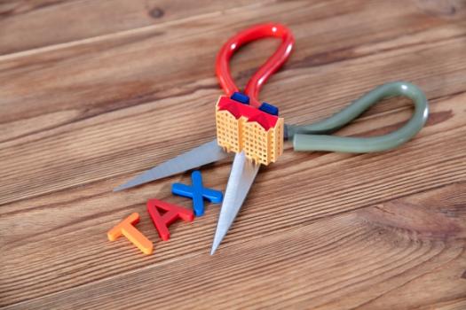 Real Estate Firms Push to Preserve Carried Interest Tax Break Scissors with tax on it