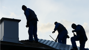Three contractors repairing roof