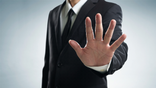 Businessman holding hand up in stop gesture