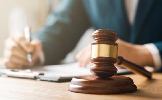 Seattle Team Obtains Summary Judgment in Real Estate Broker Professional Liability Action Gavel on desk person signing something