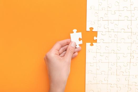 Hand putting in last puzzle piece