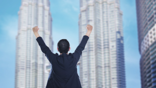 Business person standing with arms up in triumph