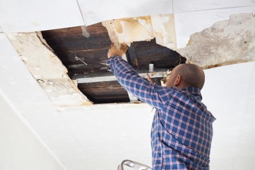 Man working on leaky ceiling