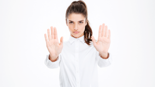 Businesswoman holding up hands in stop warning
