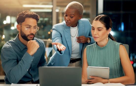 Team discussing document on laptop