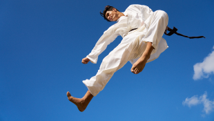 Martial artist kicking in air
