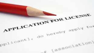 Red pencil lying on application for license