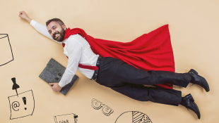 Businessman in super hero pose wearing cape