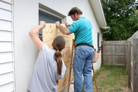 Couple boarding window for hurricane preparedness