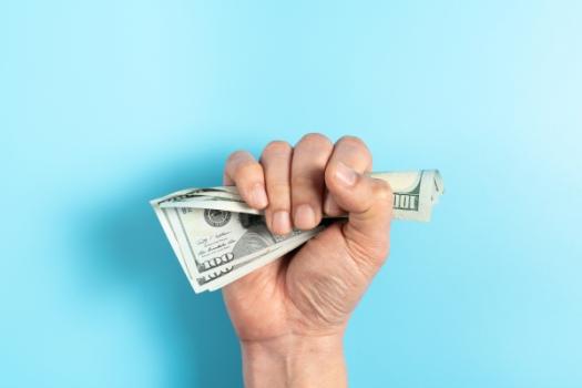 Court Resolves Disagreement on the Amount of the Deductible Hand clenching money