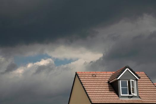 Top of home with storm clouds in sky