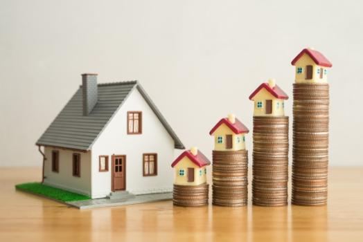 Coins stacked up next to house